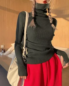 Detail of a slim-fit dark green ribbed turtleneck knit sweater in a cozy sunlit room