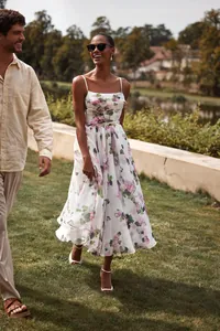 Professional model wearing a floral chiffon midi dress walking outdoors showing the flowy skirt