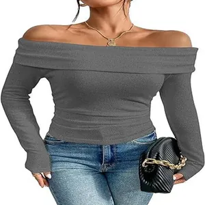 Dettaglio dell'elegante top grigio con spalle scoperte e maniche lunghe su una modella