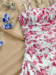 Dettaglio di un abito a fiori bianco e rosa con arricciature per vacanze al mare