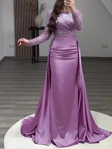 Elegant purple sequined long-sleeve evening gown with a flowing satin mermaid skirt detail