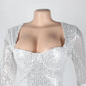 Macro detail of a white silver sequin bodycon dress featuring a deep sweetheart neckline