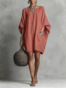 Full view of oversized terracotta batwing sleeve dress with textured fabric detail