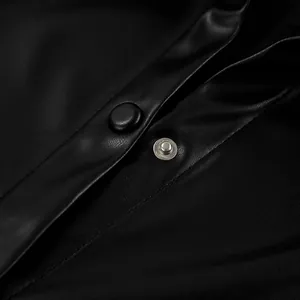 Detailed macro view of black vintage PU leather jacket featuring a snap button closure