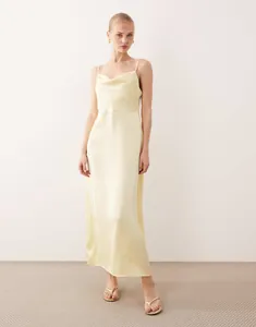 Elegant pale yellow cowl neck satin slip dress with a silky glossy luxury finish