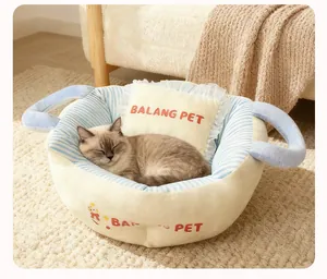 Close-up of cozy thickened pet bed with cat sleeping inside and soft pillow detail
