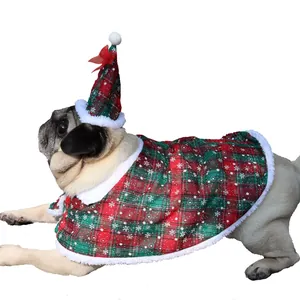 Detail view of festive red and green plaid pet Christmas cape with snowflake patterns