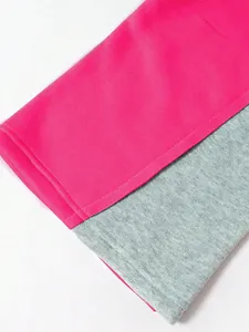 Makro-Detail des hochwertigen pinken und grauen Strickstoffs an der zweifarbigen Hose