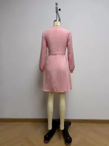Vista trasera detallada de un vestido cruzado rosa de manga larga en un maniquí.