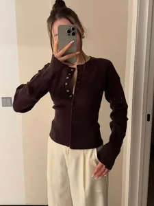 Detailansicht eines schmal geschnittenen dunkelbraunen kurzen Strick-Cardigans mit Knöpfen.