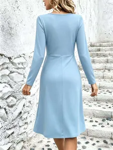 Back view of a minimalist light blue long-sleeved midi dress featuring a refined waist detail