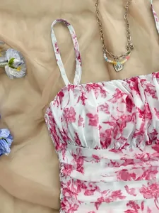 Primo piano di un abito a fiori bianchi e rosa con scollo a cuore e arricciature.