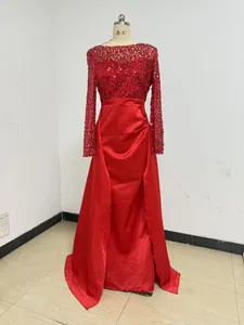 Red long-sleeved evening gown with sequined bodice and flowing satin skirt on mannequin