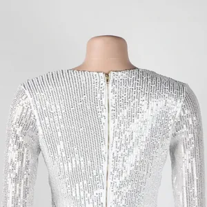 Detailed macro view of white sequined dress back featuring a golden zipper closure