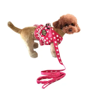 Dettaglio dell'imbracatura e del guinzaglio per cani a pois rosa per cani piccoli.