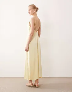 Elegant pale yellow satin slip maxi dress with open back detail for evening wear.