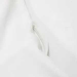 Close-up detail of white solid color jumpsuit showing the high-quality fabric stitching