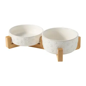 Elegant double white ceramic pet bowls with bamboo stand and embossed paw print design