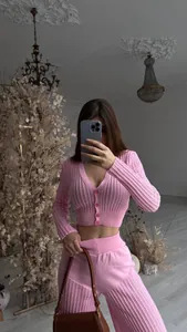 Detailed view of pink knitted set featuring hollow-out ribbed texture and cropped cardigan