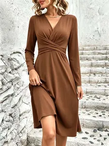 Detail of brown long sleeve V-neck midi dress with elegant waist cross pleats