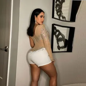 Elegante vista laterale di un body sexy con strass e pantaloncini bianchi per la serata