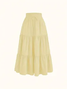 Detail of a light yellow plus size tiered maxi skirt with elastic drawstring waist.