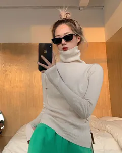 Close-up detail of high-neck cream ribbed knit sweater for women in indoor setting