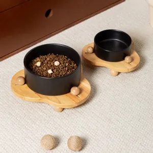 Set di due ciotole in ceramica nera opaca con supporti in rovere su un tappeto