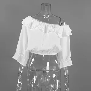 Détail du chemisier blanc à volants avec épaule dénudée et taille élastique courte