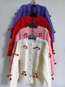 Detailed view of four cherry-themed knitted cardigans in white, pink, red, and purple.