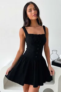 Détail d'une élégante robe noire cintrée avec décolleté carré et boutons sur le devant.