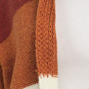 Detalle macro de la textura de un cárdigan de punto a rayas de colores en jengibre y granate
