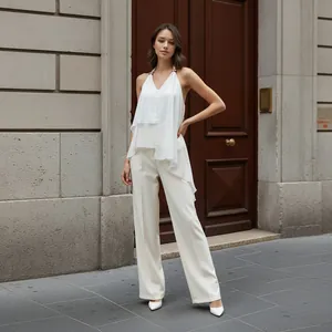 Full-length view of white asymmetrical halter chiffon top paired with wide-leg pants