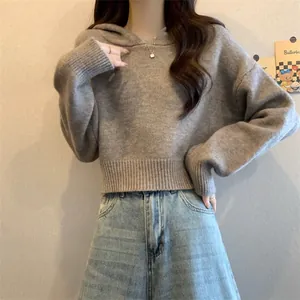 Femme portant un pull court gris à capuche en maille avec manches amples et jean