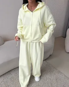 Women's pale yellow two-piece tracksuit set with a zip-up hoodie and wide-leg pants
