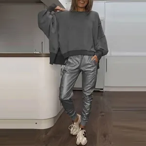 Casual women's side slit crewneck sweatshirt and metallic jogger pants set in a modern home