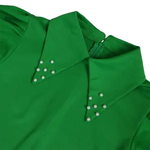 Close-up detail of green commuter dress collar with elegant white pearl beading
