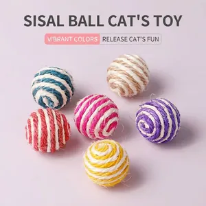 Primo piano di sei palline colorate per gatti in corda di sisal su sfondo viola