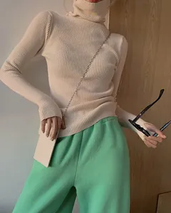Close-up of elegant beige ribbed turtleneck knit sweater showing slim fit and texture.