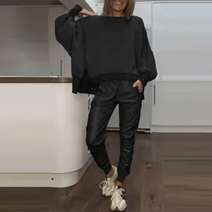 Detail shot of a women's black two-piece lounge set with side-slit crewneck sweatshirt
