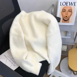 Gros plan sur un pull en fausse fourrure de vison blanc crème à texture tricotée