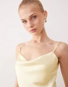 Elegant yellow satin slip dress featuring a draped cowl neck and slim straps detail.