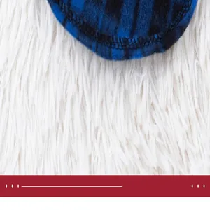Dettaglio ravvicinato delle cuciture di un gilet in pile scozzese blu per animali domestici.