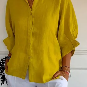 Detailansicht eines senfgelben Leinenhemdes mit eleganten Knöpfen und Puffärmeln.