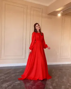 Full view of elegant red chiffon gown showcasing puff sleeves and flowing skirt design