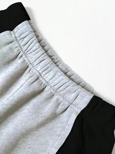 Detailansicht des gerafften Gummibundes an grau-schwarzer Colorblock-Jogginghose