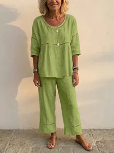 Casual two-piece linen-style set in vibrant green featuring decorative hollow-out details.