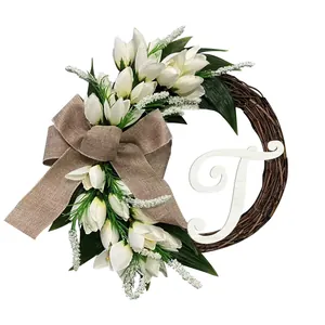 Elegant simulated white tulip wreath with burlap bow and white wooden letter T decoration