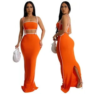 Detail view of a vibrant orange two-piece maxi set with white piping and back slit