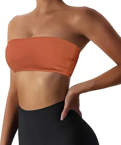 Detail view showing the texture and fit of a burnt orange strapless tube top sports bra for women.